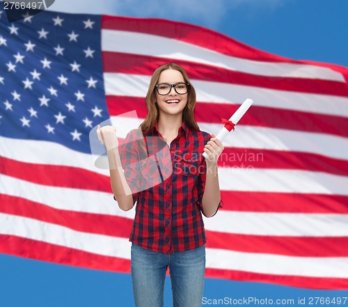 Image of smiling female student in eyeglasses with diploma