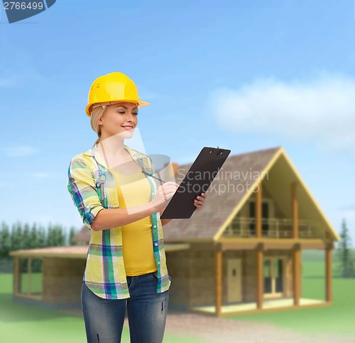 Image of smiling woman in helmet with clipboard