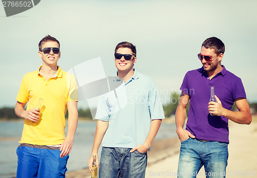 Image of friends on the beach with bottles of drink