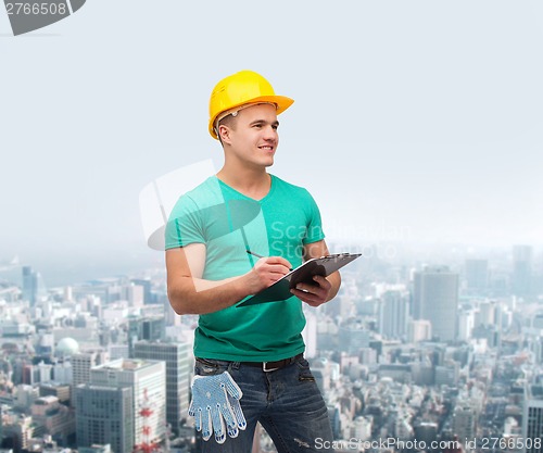 Image of smiling man in helmet with clipboard