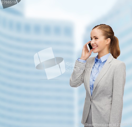 Image of young smiling businesswoman with smartphone