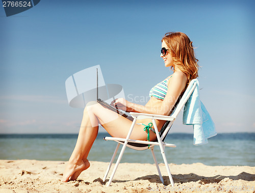 Image of girl looking at tablet pc on the beach