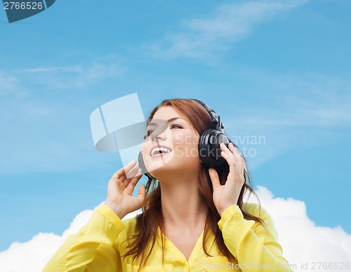 Image of smiling young girl in headphones at home