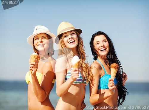 Image of girls in bikinis with ice cream on the beach