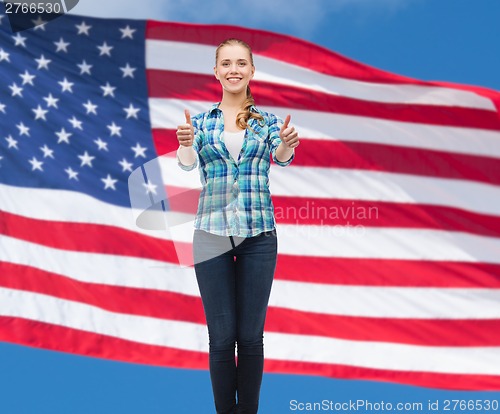 Image of young woman in casual clothes showing thumbs up