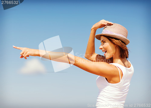 Image of girl in hat showing direction on the beach