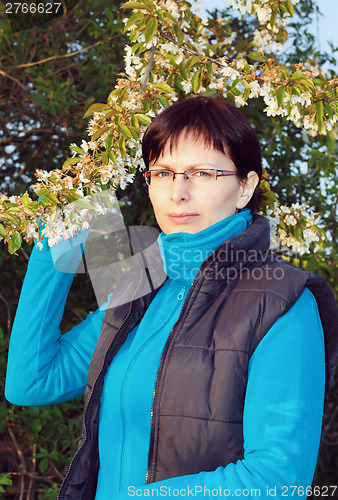 Image of happy smiling middle age woman outdoor with tree