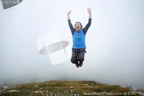 Image of Man jumping on mountain peak