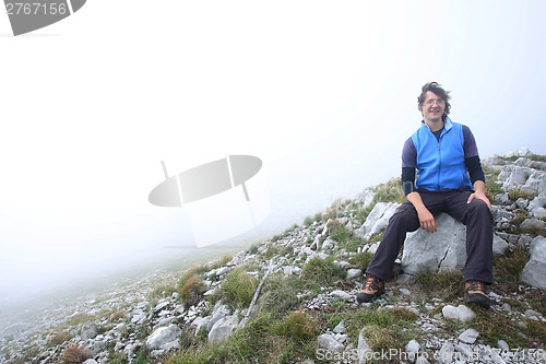 Image of Man sitting on mountain peak