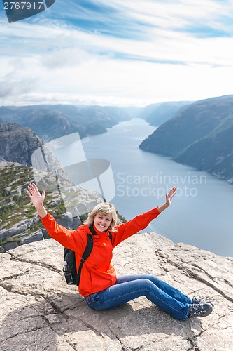 Image of Woman sitting on Pulpit Rock / Preikestolen, Norway