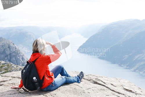 Image of Woman sitting on Pulpit Rock / Preikestolen, Norway