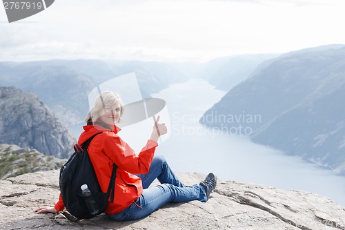 Image of Woman sitting on Pulpit Rock / Preikestolen, Norway