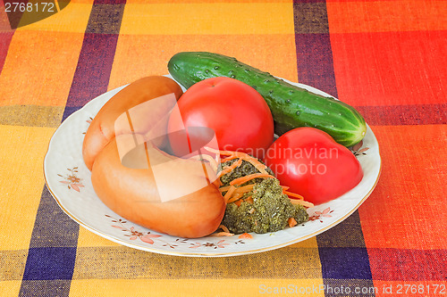 Image of Two big sausages and vegetables on a white dish.