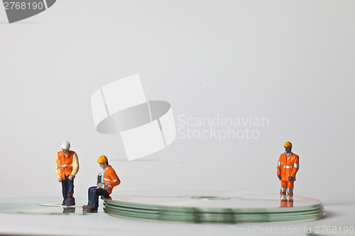 Image of Miniature people in action with CDs