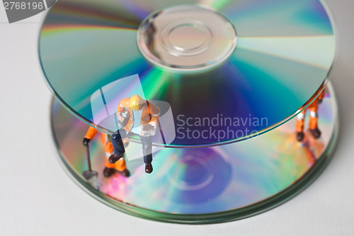 Image of Miniature people in action with CDs