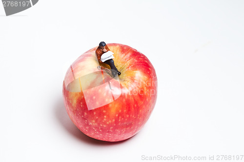 Image of Miniature people in action sitting on an apple