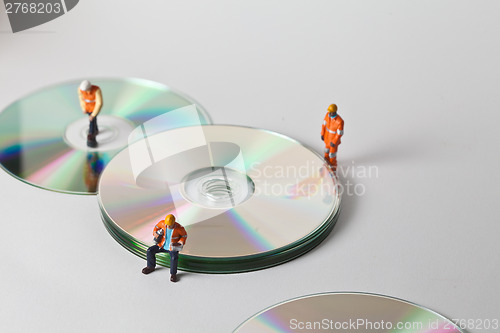 Image of Miniature people in action with CDs