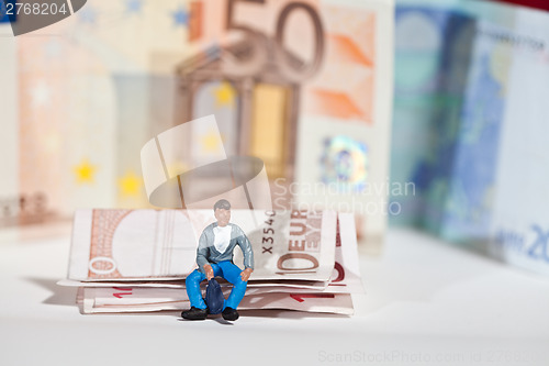Image of Miniature people in action with euro banknotes