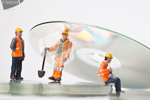 Image of Miniature people in action with CDs