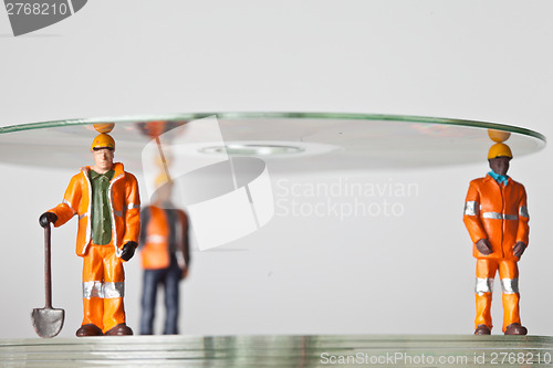 Image of Miniature people in action with CDs