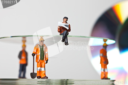 Image of Miniature people in action with CDs