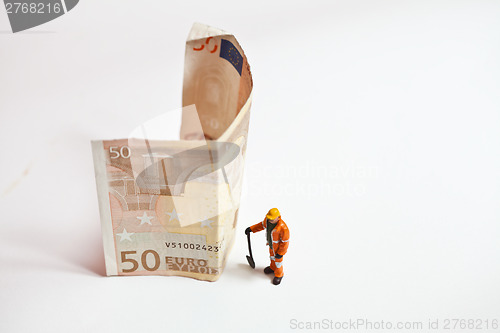 Image of Miniature people in action with euro banknotes