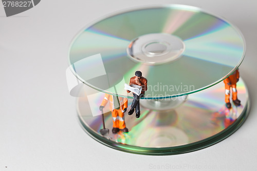 Image of Miniature people in action with CDs