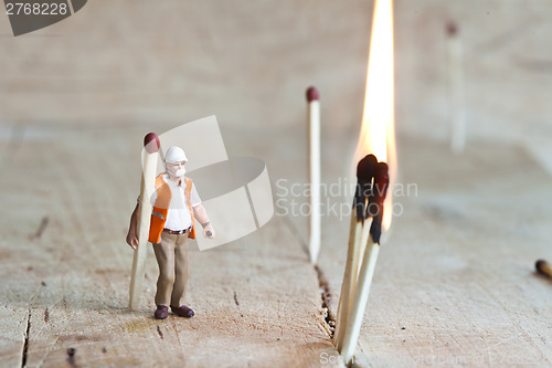 Image of Miniature people in action with matchsticks