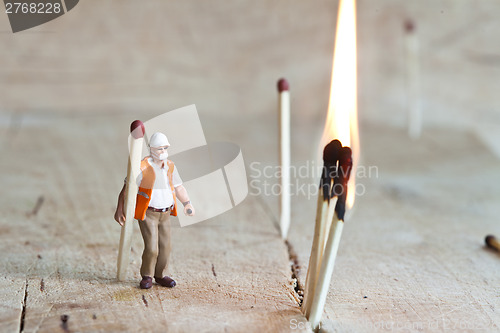 Image of Miniature people in action with matchsticks