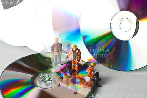 Image of Miniature people in action with CDs