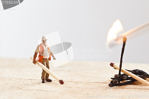 Image of Miniature people in action with matchsticks