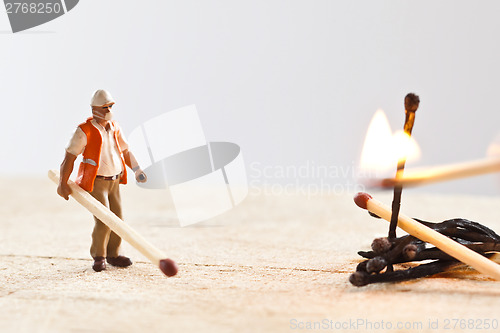 Image of Miniature people in action with matchsticks