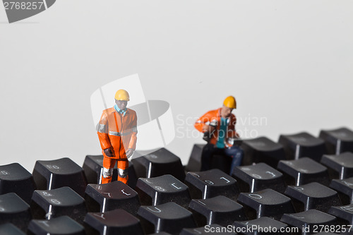 Image of Miniature people in action on a computer keyboard