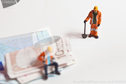 Image of Miniature people in action with euro banknotes