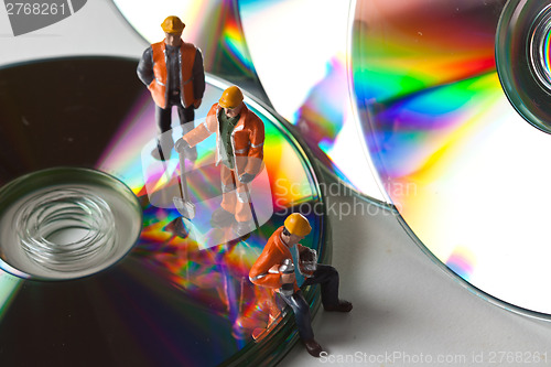 Image of Miniature people in action with CDs