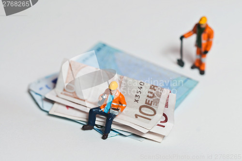 Image of Miniature people in action with euro banknotes