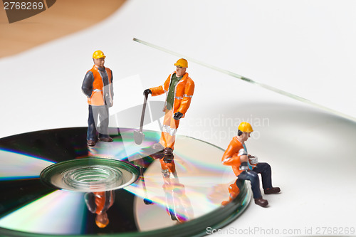 Image of Miniature people in action with CDs