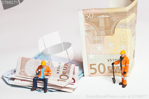 Image of Miniature people in action with euro banknotes