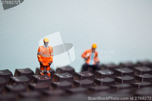 Image of Miniature people in action on a computer keyboard