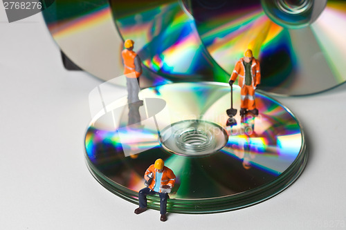 Image of Miniature people in action with CDs