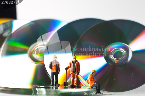 Image of Miniature people in action with CDs