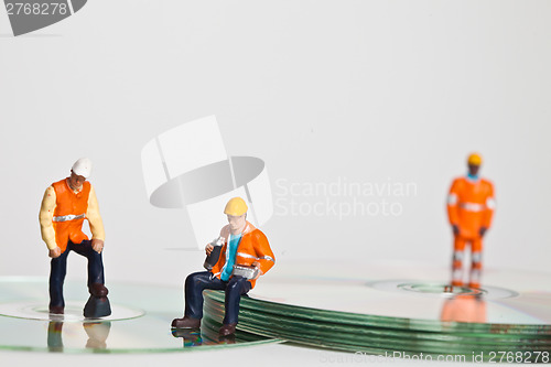 Image of Miniature people in action with CDs