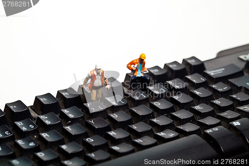 Image of Miniature people in action on a computer keyboard