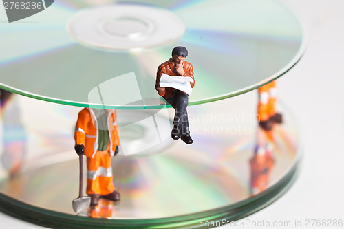 Image of Miniature people in action with CDs