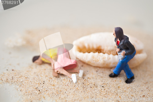 Image of Miniature people sitting on a shell