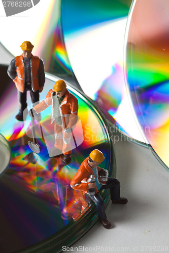 Image of Miniature people in action with CDs