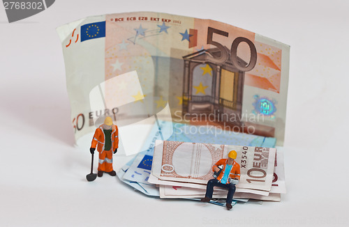 Image of Miniature people in action with euro banknotes