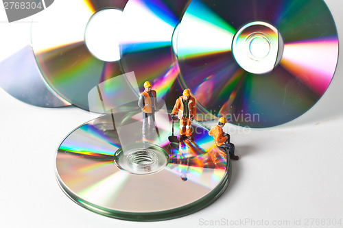 Image of Miniature people in action with CDs