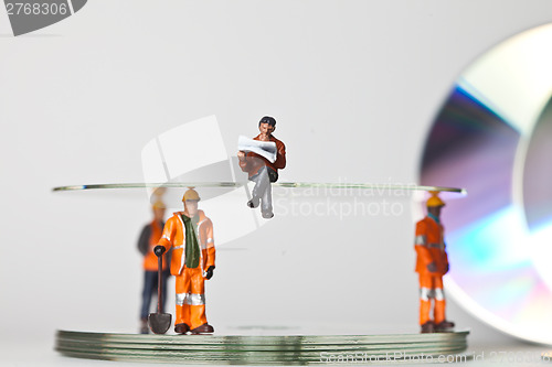 Image of Miniature people in action with CDs