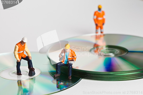 Image of Miniature people in action with CDs